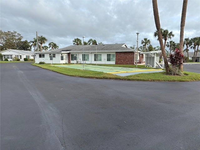 single story home featuring a front yard, brick siding, and driveway