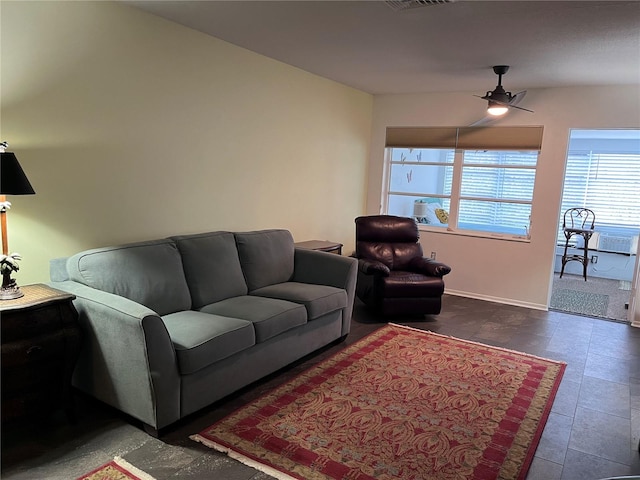 living room featuring ceiling fan, visible vents, and baseboards