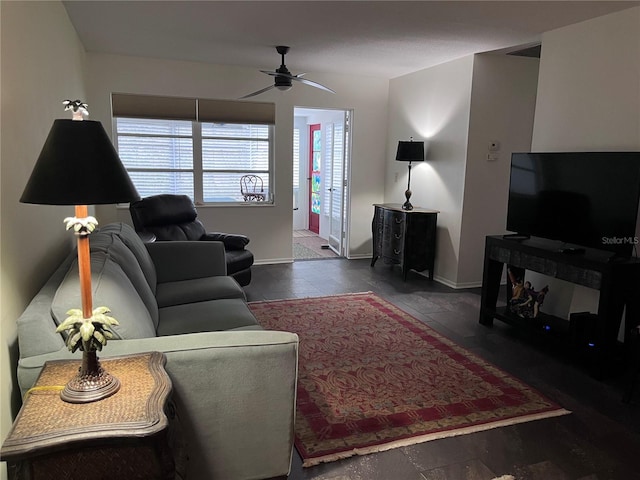 living room featuring baseboards and a ceiling fan