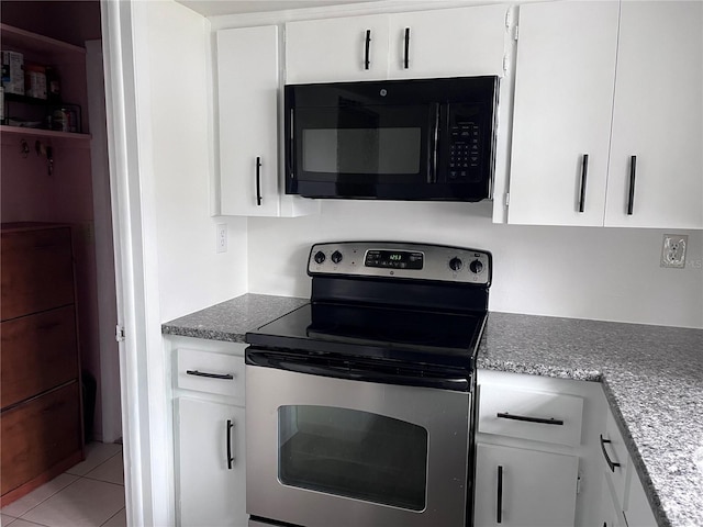 kitchen with stainless steel range with electric stovetop, black microwave, white cabinetry, and light tile patterned floors