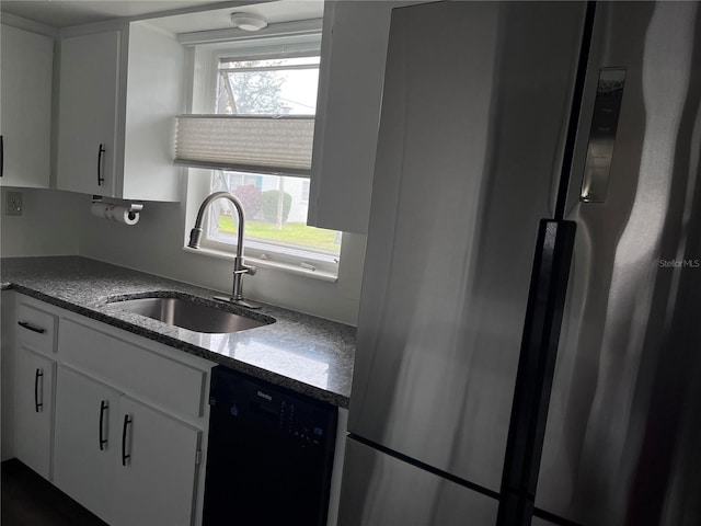 kitchen featuring freestanding refrigerator, a healthy amount of sunlight, dishwasher, and a sink