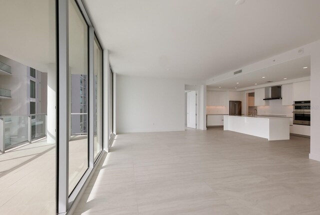301 Quay Commons Unit 1111, Sarasota, FL 34236 - unfurnished living room featuring expansive windows and a sink