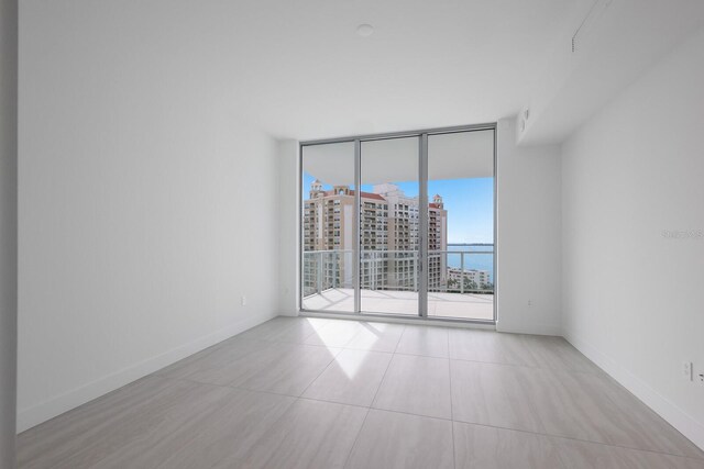 301 Quay Commons Unit 1111, Sarasota, FL 34236 - empty room featuring expansive windows and baseboards