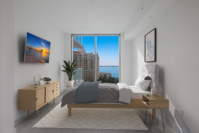 301 Quay Commons Unit 1111, Sarasota, FL 34236 - bedroom with a wall of windows, wood finished floors, and baseboards