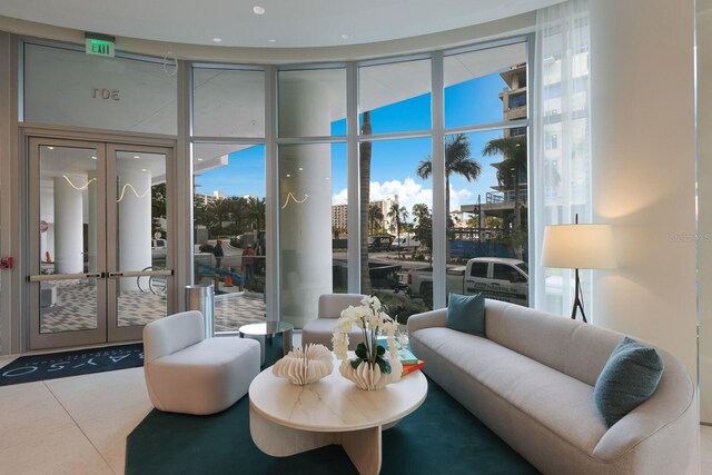 301 Quay Commons Unit 1111, Sarasota, FL 34236 - living room with tile patterned floors, french doors, and a wall of windows