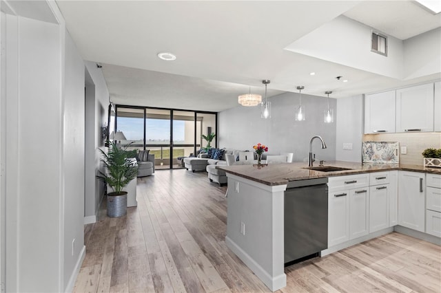 kitchen featuring dishwasher, sink, kitchen peninsula, white cabinets, and light wood-type flooring