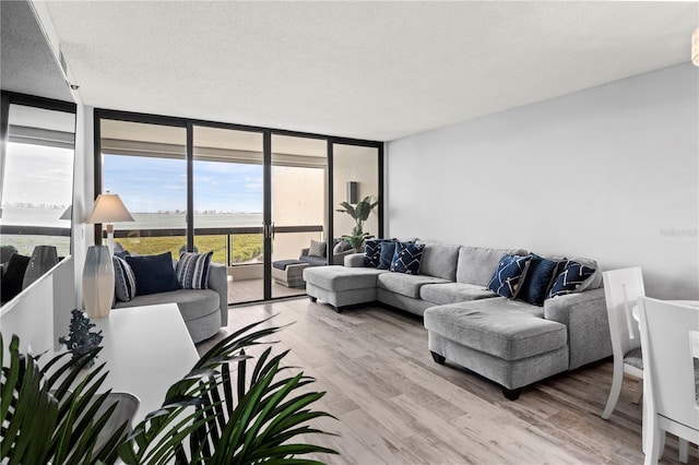 living room featuring hardwood / wood-style floors, a textured ceiling, and floor to ceiling windows