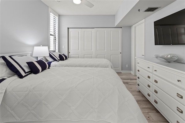 bedroom featuring light hardwood / wood-style floors, a closet, and ceiling fan