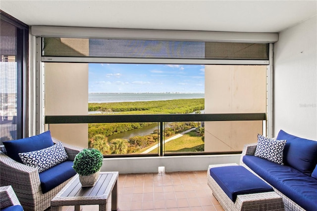 sunroom featuring a beach view and a water view