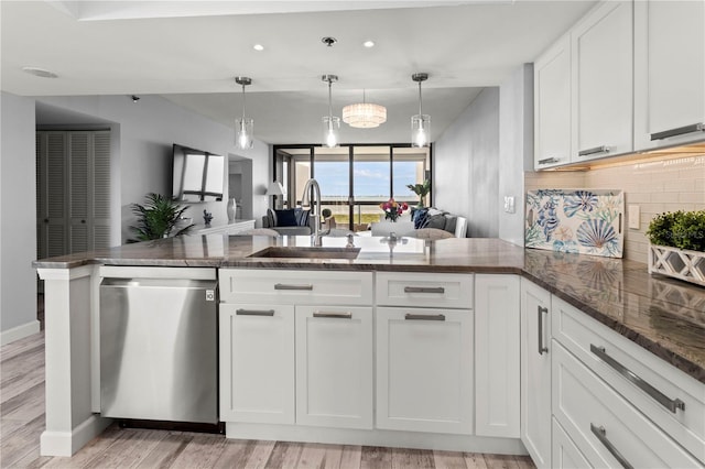 kitchen with kitchen peninsula, stainless steel dishwasher, sink, light hardwood / wood-style floors, and white cabinetry