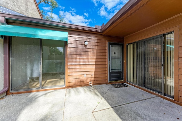 view of exterior entry featuring a patio area