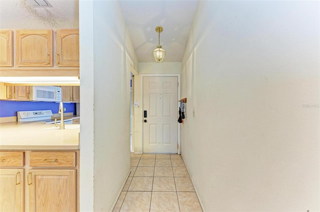 entryway with light tile patterned flooring and a textured ceiling