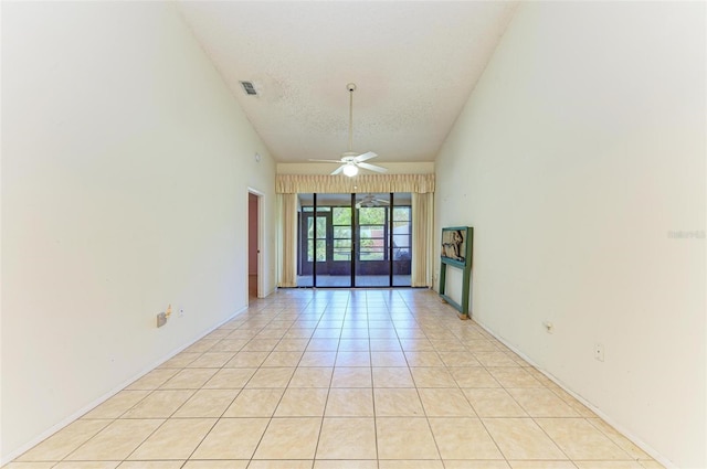 spare room featuring high vaulted ceiling, french doors, ceiling fan, light tile patterned floors, and a textured ceiling