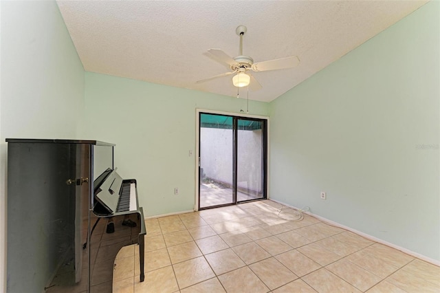 interior space featuring a textured ceiling, ceiling fan, and light tile patterned flooring