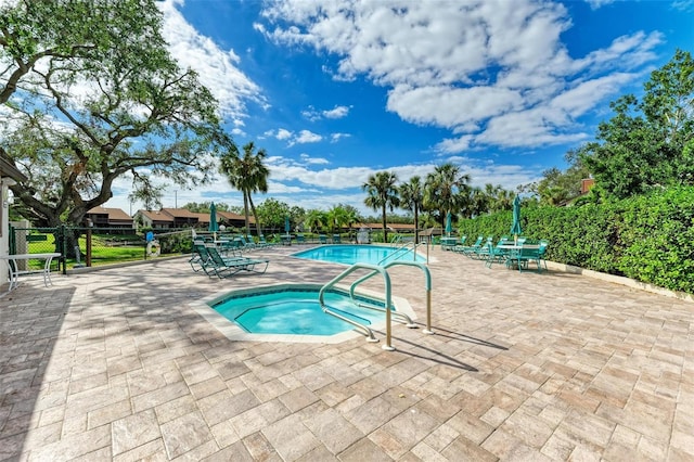 view of swimming pool featuring a community hot tub and a patio