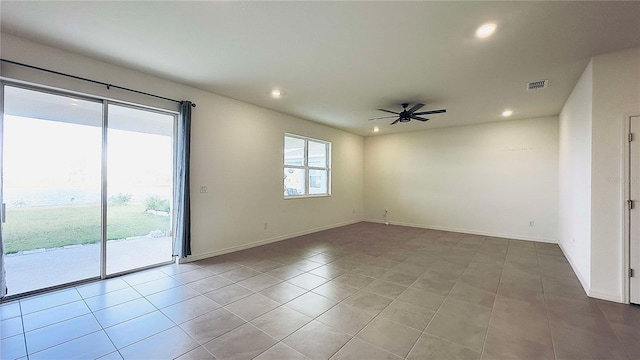 empty room with ceiling fan and light tile patterned floors