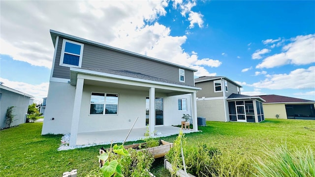 back of property featuring a sunroom and a lawn