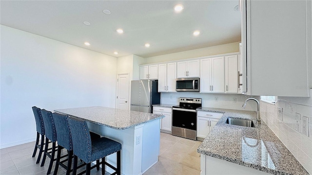 kitchen featuring white cabinets, a center island, sink, and stainless steel appliances