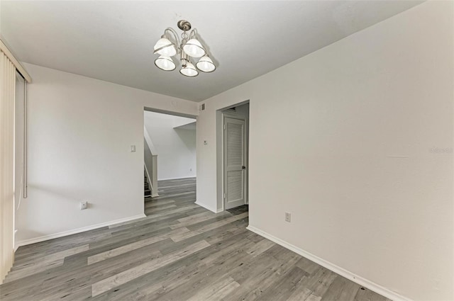 unfurnished dining area with a chandelier and hardwood / wood-style floors