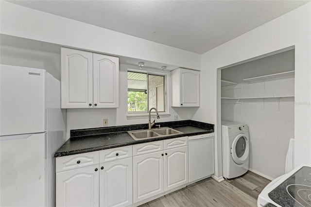 kitchen with white appliances, white cabinets, sink, light wood-type flooring, and washer / clothes dryer