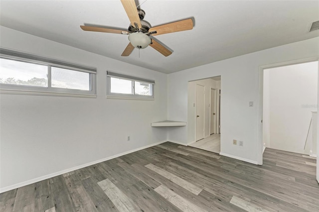 unfurnished bedroom featuring hardwood / wood-style flooring, ceiling fan, and a closet