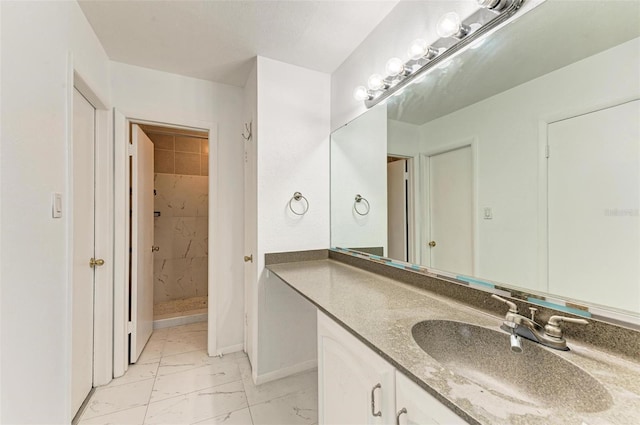 bathroom featuring a tile shower and vanity