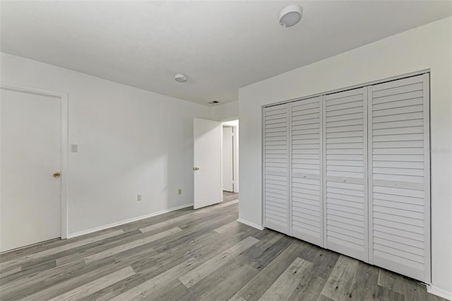 unfurnished bedroom featuring light wood-type flooring and a closet