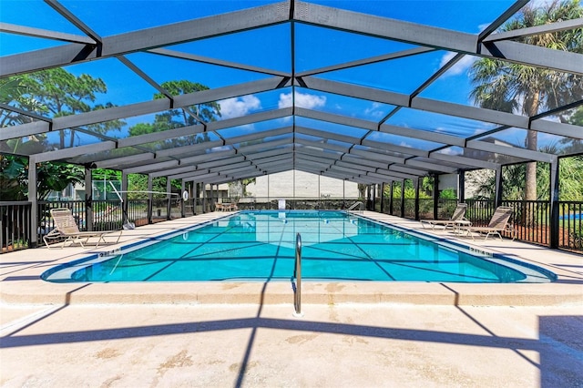 view of swimming pool with a patio and glass enclosure