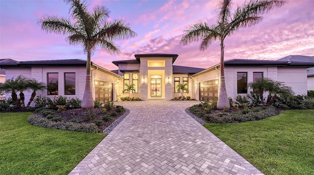 view of front facade with a garage and a yard