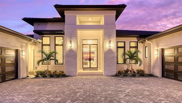 exterior entry at dusk with a garage