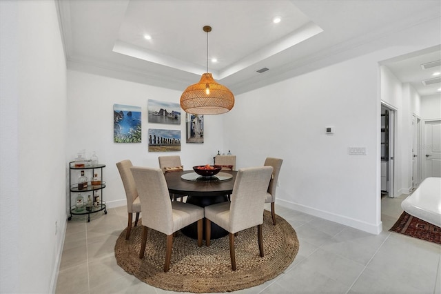 tiled dining space featuring a tray ceiling