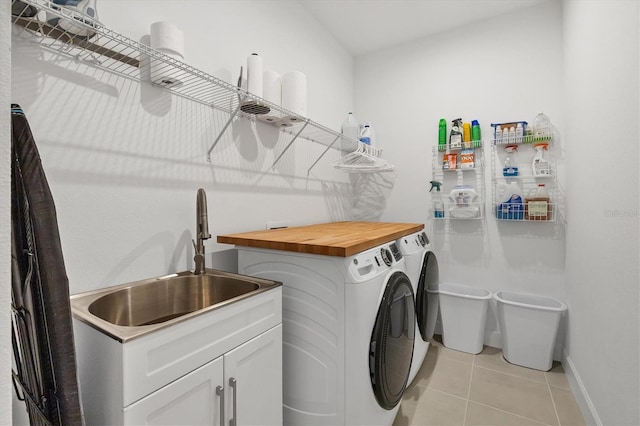 laundry room featuring washer and dryer, cabinets, light tile patterned floors, and sink