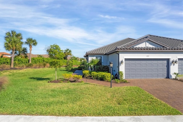 view of front of property with decorative driveway, a front yard, an attached garage, stucco siding, and a tile roof