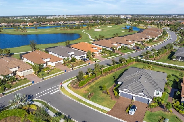 view of property location featuring nearby suburban area, a nearby body of water, and a local golf course