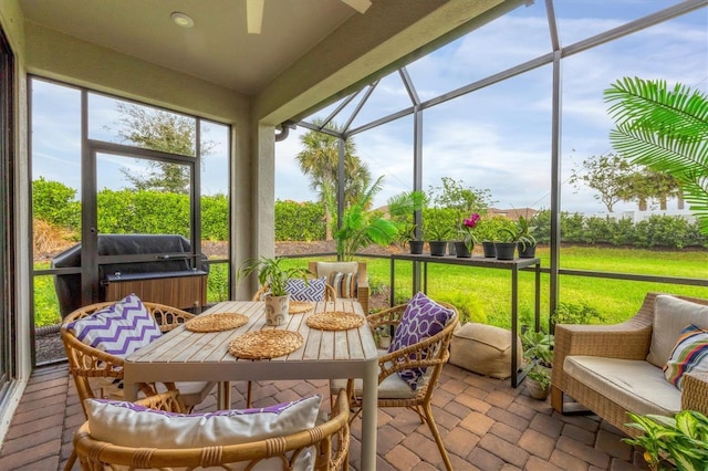 sunroom / solarium featuring a ceiling fan and outdoor dining area