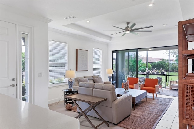 living room with healthy amount of natural light, ceiling fan, recessed lighting, a raised ceiling, and light tile patterned floors