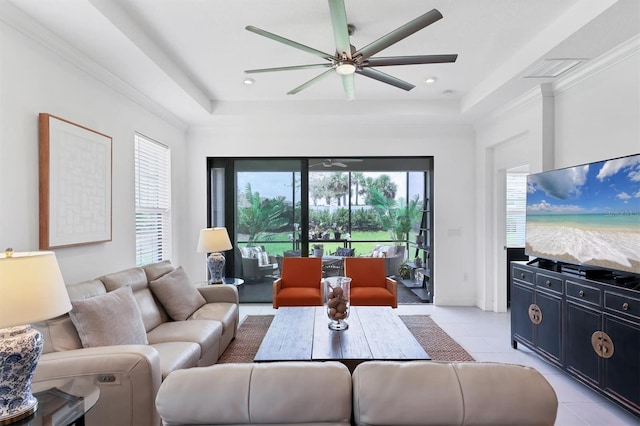 living room with ceiling fan, light tile patterned flooring, and a tray ceiling