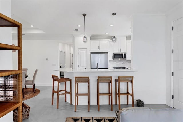 kitchen with appliances with stainless steel finishes, a breakfast bar area, backsplash, a peninsula, and recessed lighting