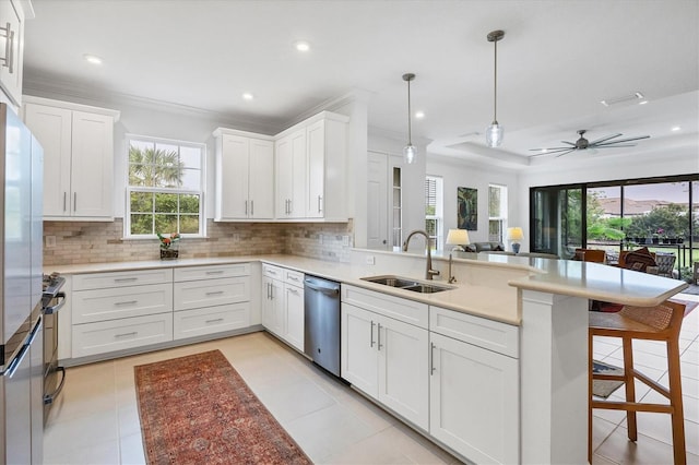 kitchen with a sink, stainless steel appliances, a peninsula, healthy amount of natural light, and recessed lighting