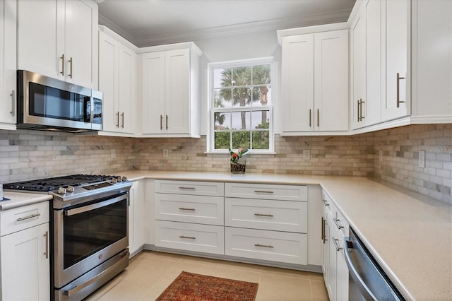 kitchen with stainless steel appliances, ornamental molding, white cabinetry, light countertops, and light tile patterned floors