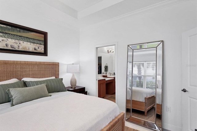 bedroom featuring baseboards, crown molding, and ensuite bath