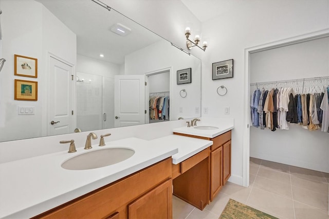 full bath with a shower stall, tile patterned floors, double vanity, and a spacious closet