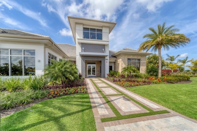 view of front of house with stucco siding and a front yard
