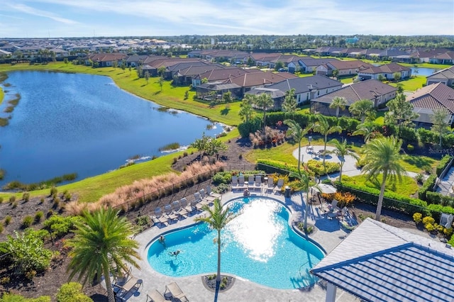 aerial perspective of suburban area with a pool area and a nearby body of water