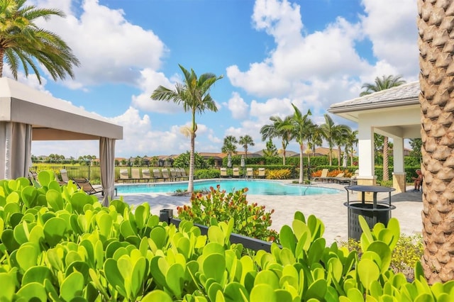 community pool with a patio and fence