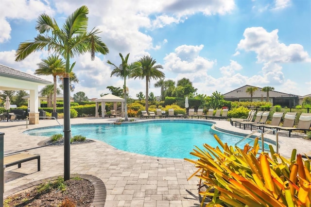 community pool with a gazebo, a patio, and fence