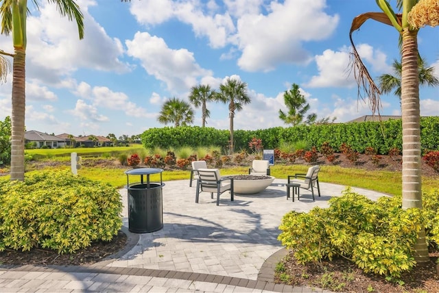 view of property's community with a patio and an outdoor fire pit