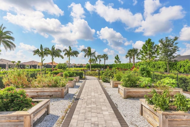 view of home's community with a vegetable garden, fence, and a residential view