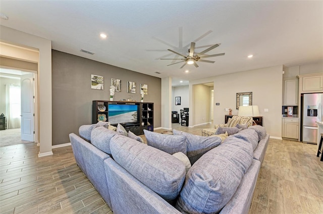 living room featuring light wood-type flooring and ceiling fan