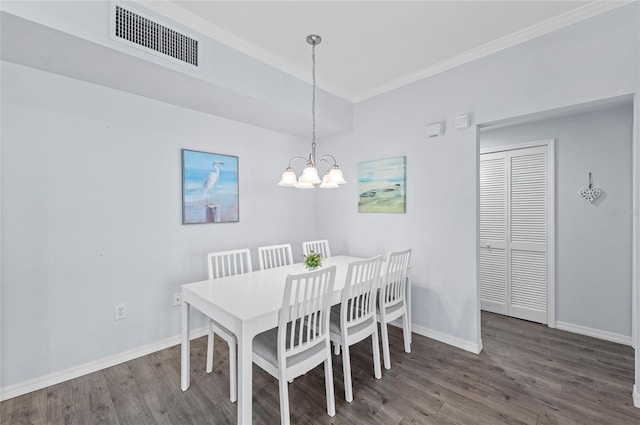 dining space with dark hardwood / wood-style floors, crown molding, and a notable chandelier